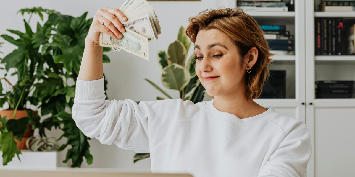 Someone looking happy and relieved while working remotely, symbolizing financial success and flexibility.