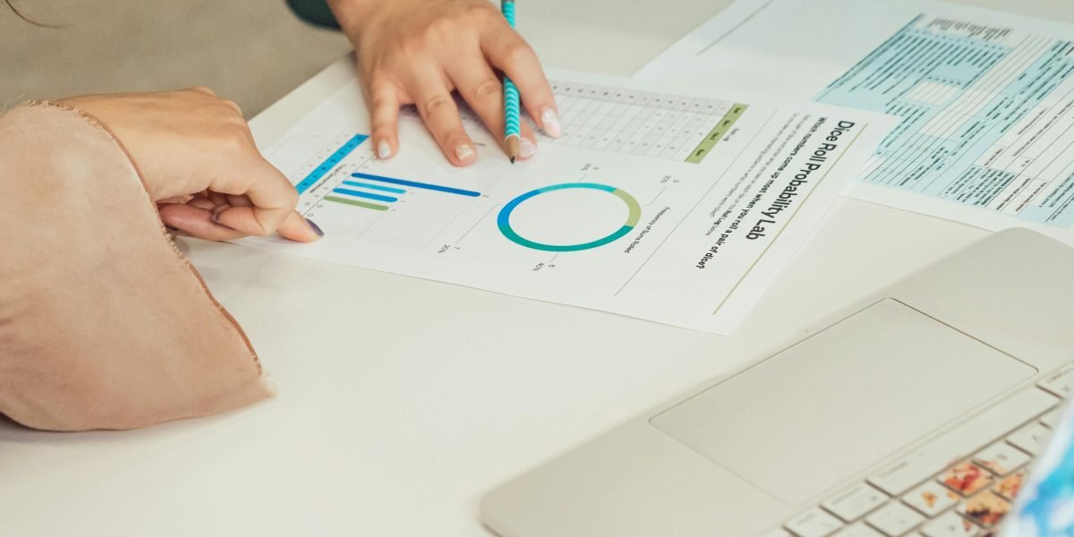 A professional carefully examining various business reports and charts to make informed decisions.