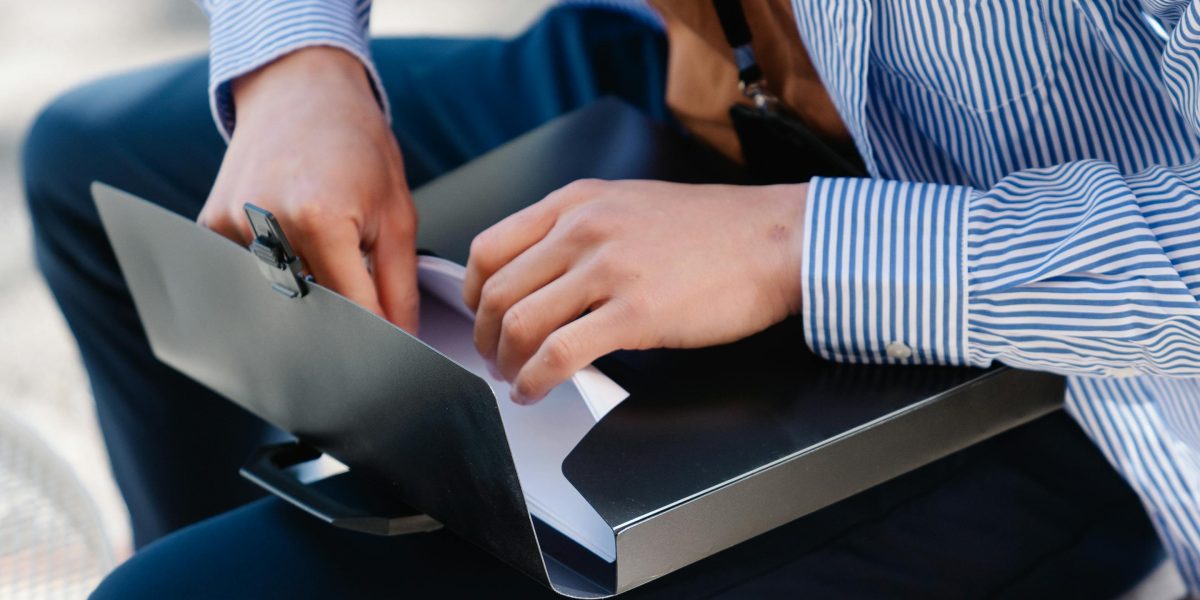 A person focused on carefully reviewing important documents and program terms before making a commitment.