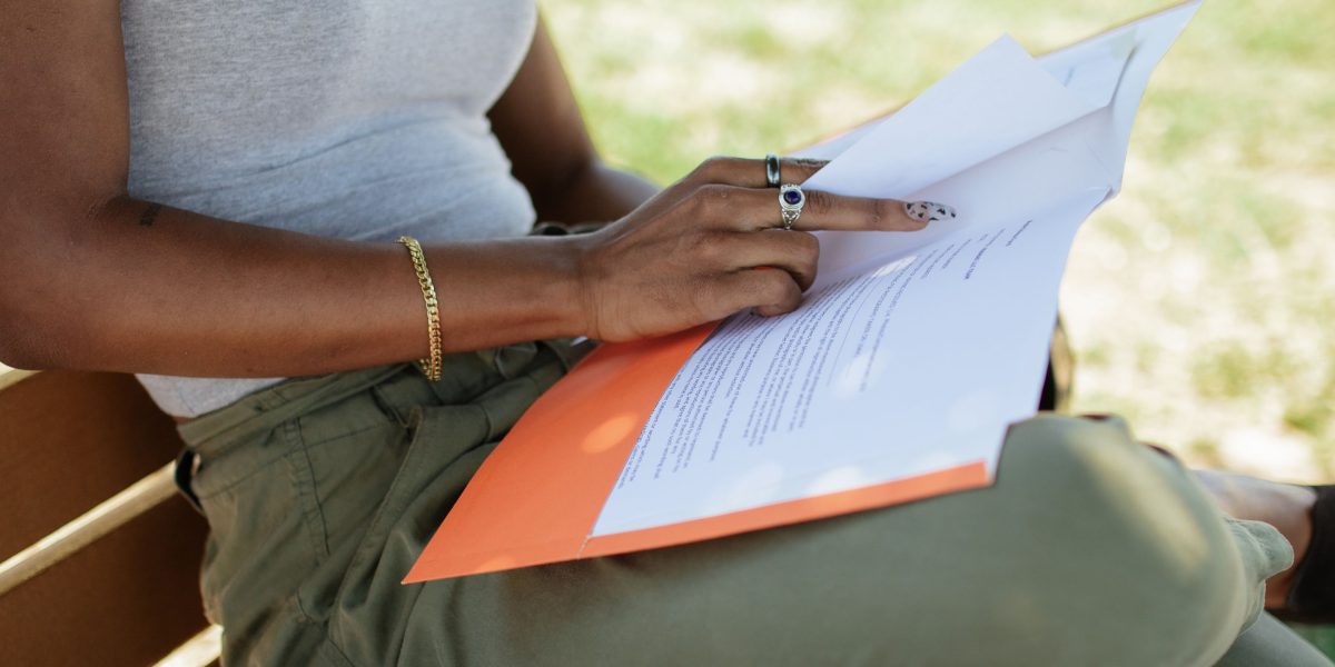 A person reviewing financial documents, emphasizing the importance of careful comparison in finance.
