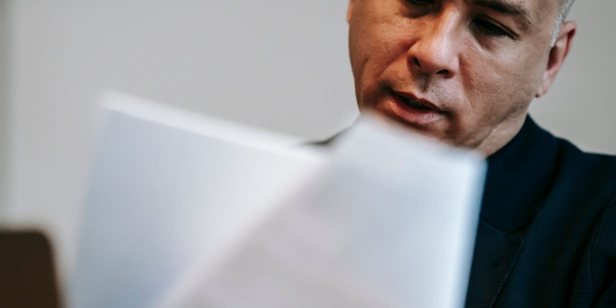 A person diligently reviewing documents, symbolizing adherence to legal and ethical guidelines.