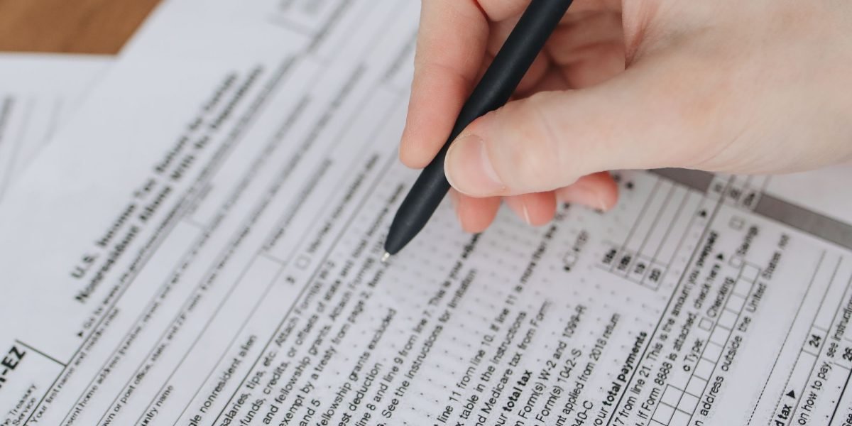 A person diligently filling out an application form for an affiliate program, ensuring all details are accurate.