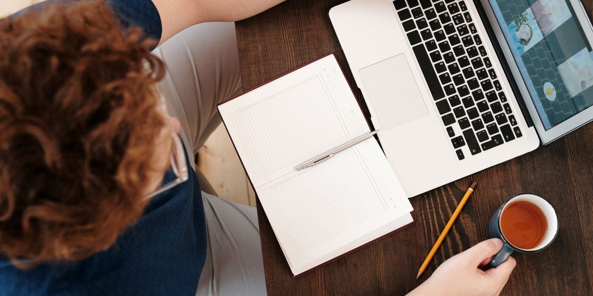 An individual thoughtfully reviewing documents in a collaborative office space, symbolizing the process of learning and starting an online business.