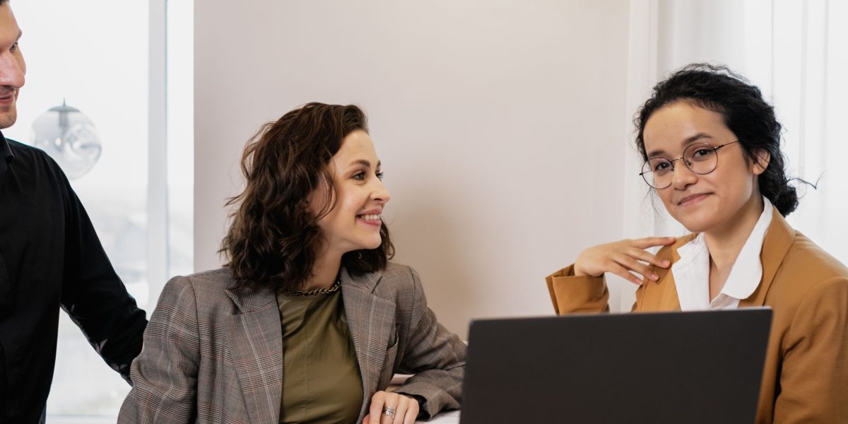 A business consultant discusses strategies and solutions with clients in a meeting setting.