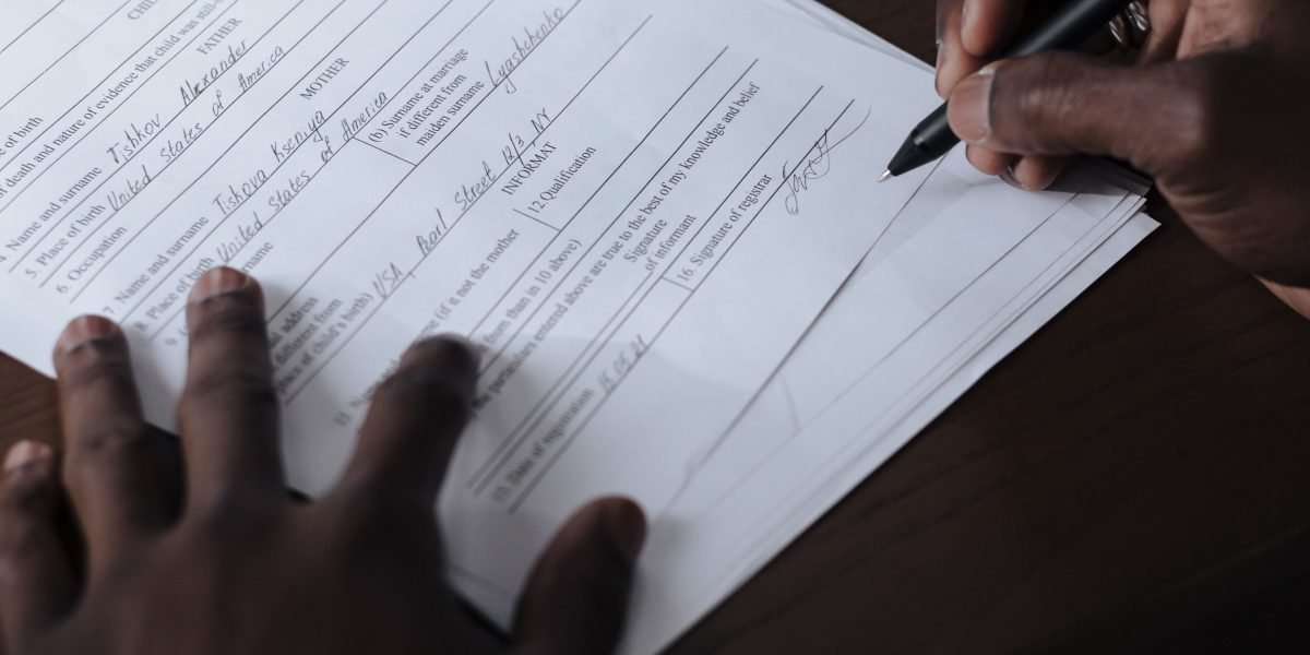 A person carefully reviewing terms and conditions of a legal document, possibly an affiliate agreement.
