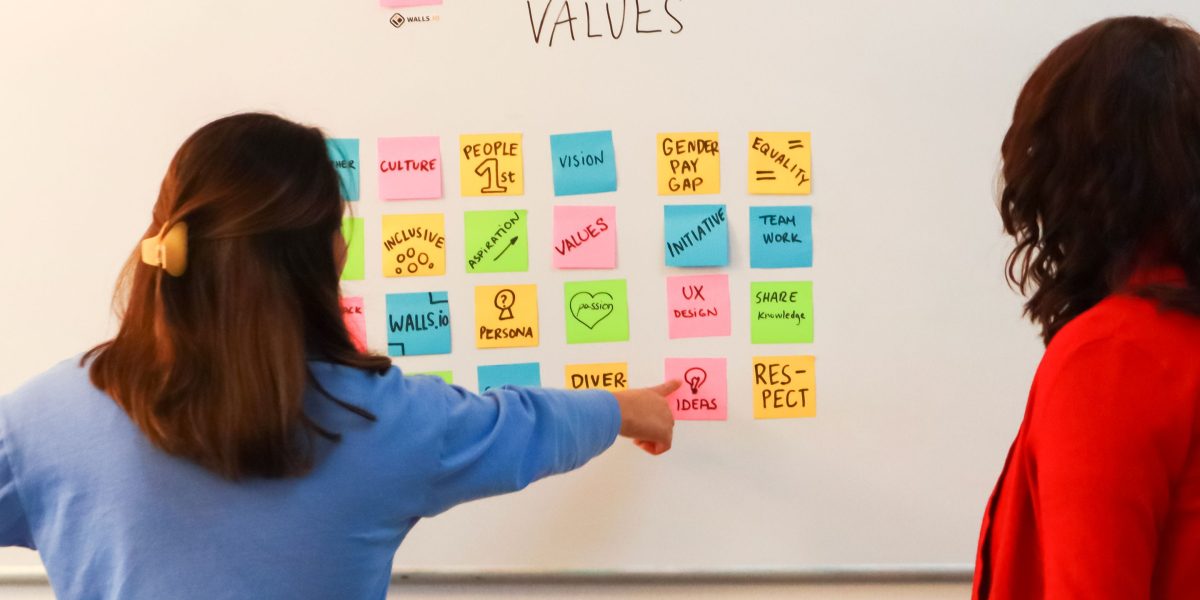 A team collaborating around a whiteboard, discussing strategies for implementing reliable affiliate tracking systems.