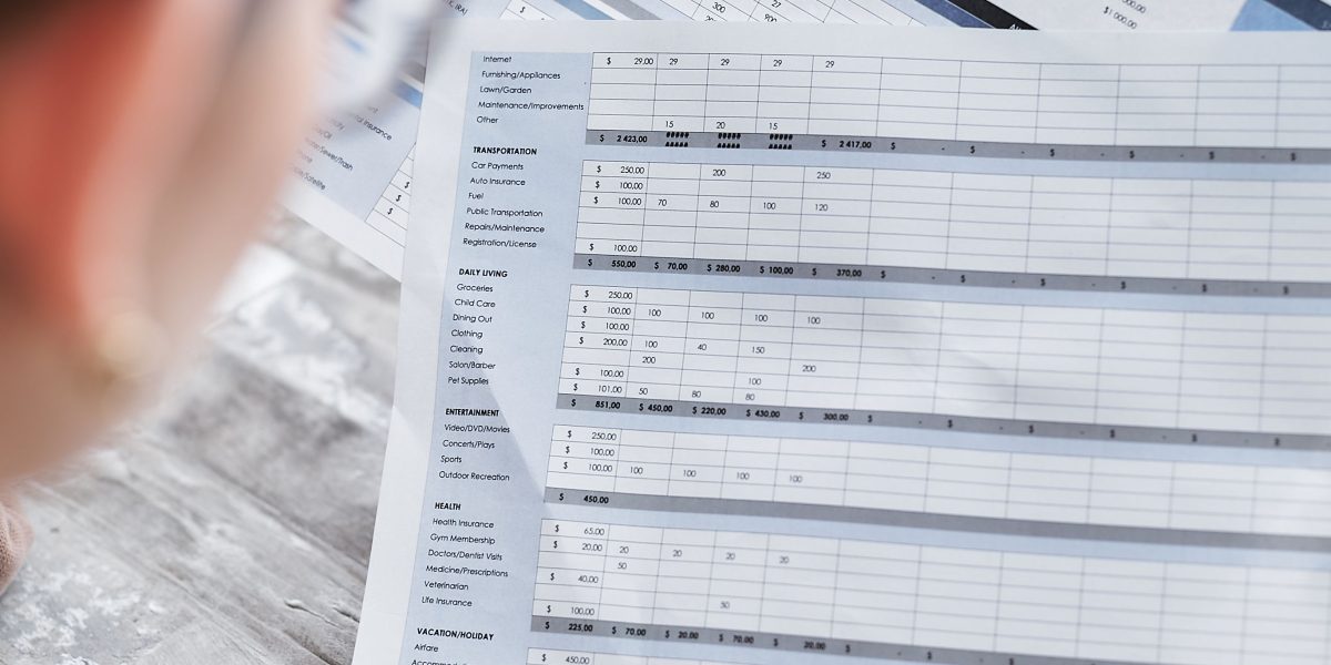 An individual carefully reviewing financial documents, symbolizing the process of reconciling affiliate reports for accuracy.